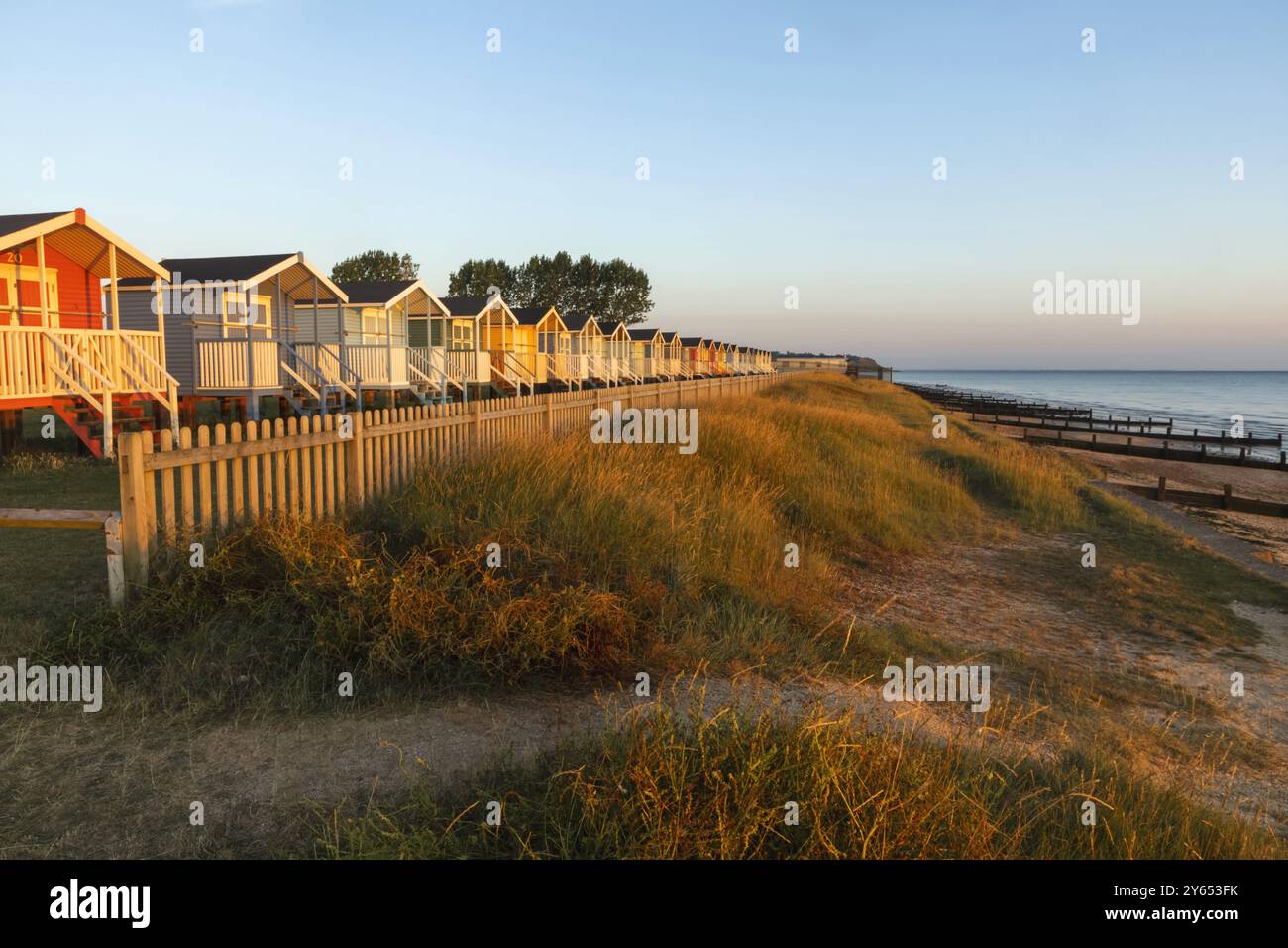 England, Kent, Isle of Sheppey, Leysdown on Sea, Row of Colourful Beach Huts Stock Photo