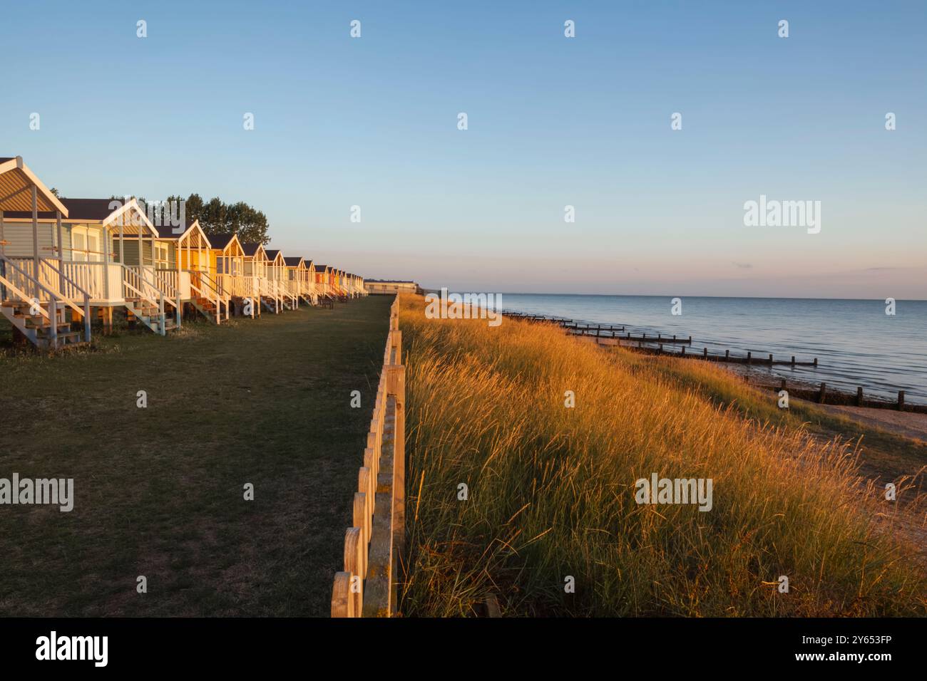England, Kent, Isle of Sheppey, Leysdown on Sea, Row of Colourful Beach Huts Stock Photo