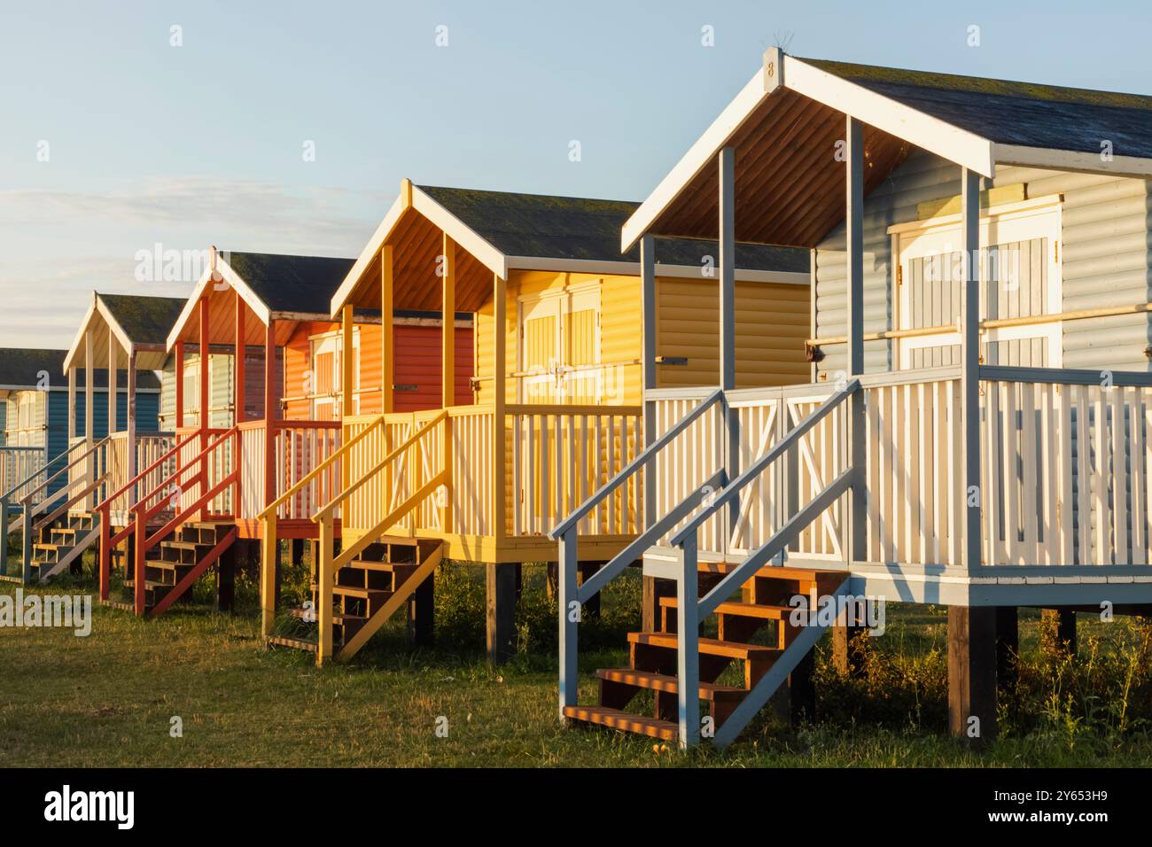 England, Kent, Isle of Sheppey, Leysdown on Sea, Row of Colourful Beach Huts Stock Photo
