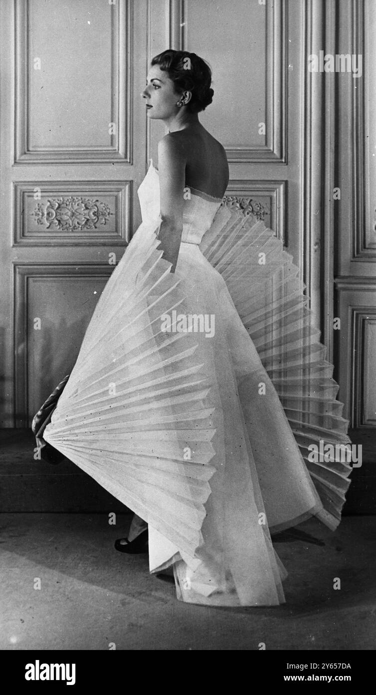 Appearing in her Summer collection this evening gown by Schiaparelli , " No  262 " is of white organdy . Two large pleated organdy bows jut out from the  skirt , whose