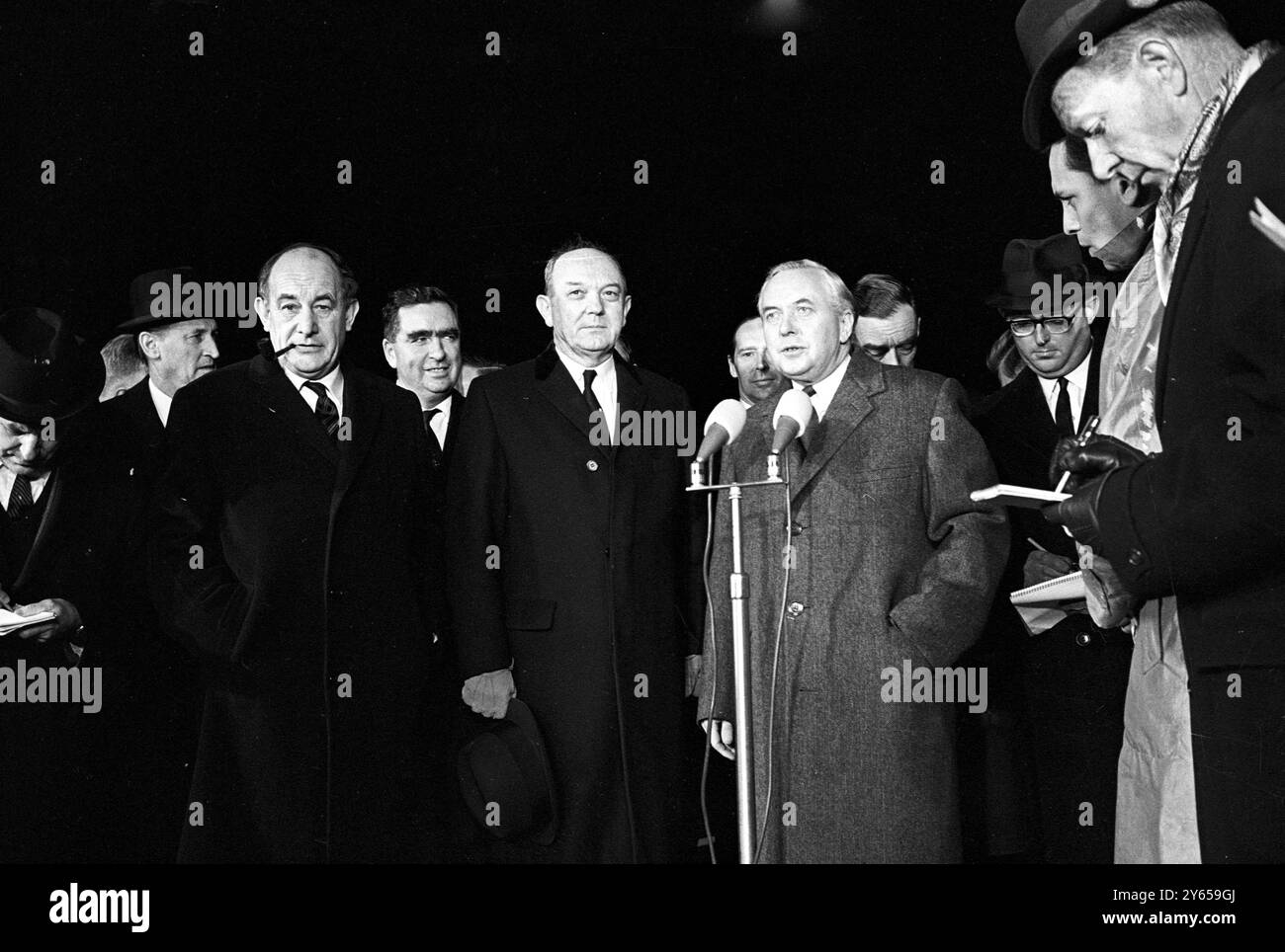 British Prime Minister Harold Wilson (right) is pictured on his arrival at Andrews Air Force base in Washington for talks with President Johnson.  Also seen in this picture are British foreign secretary Patrick Gordon Walker (left with pipe ); Defence Minister Denis Healey (right of Walker ) ; Dean Rusk , US Secretary fo State , (centre) and behind and between Rusk and Wilson  , Lord Harlech , British ambassador to the US . 8th December 1964 Stock Photo