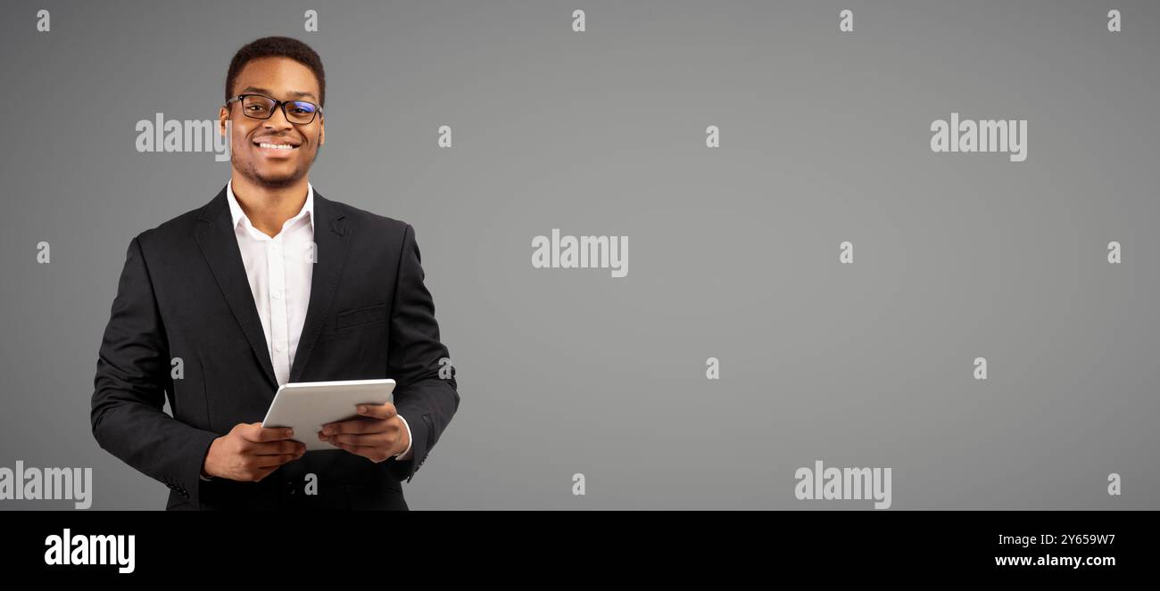 Smiling afro man standing with tablet at studio Stock Photo