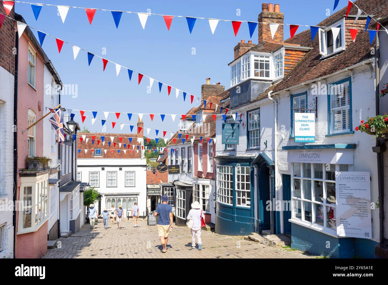 Lymington Quay hill - People walking along cobbled Quay hill a street with Bunting in Lymington Hampshire New Forest Hampshire England UK GB Europe Stock Photo