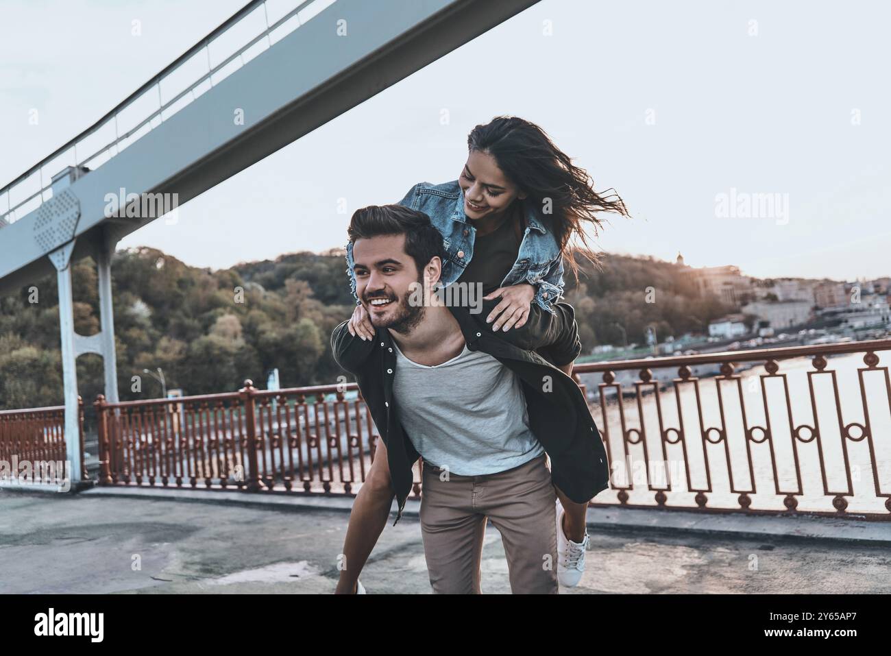 Enjoying every moment together. Young couple having fun outdoors while ...