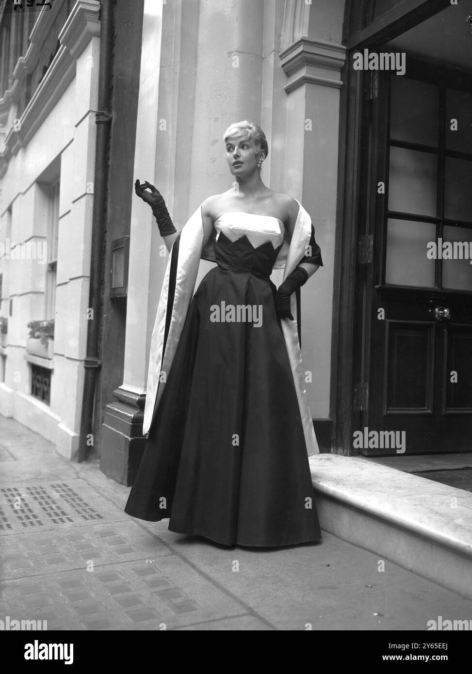 Autumn evening dress ;  Stately full length , high busted , evening dress comes from the Alice Edwards evening collection .  Called ' Marighy ', it is in woven brocade .  The model is Sonia Hamilton .   13 June 1957 Stock Photo