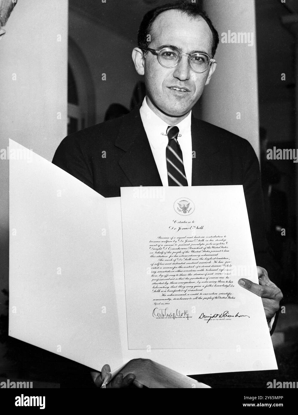 Washington ;   The world ' s thanks for his achievments are expressed in the citation Dr Jonas Salk holds .  Presented by President Eisenhower , the tribute praises Dr Salk ' s ' signal and historic contributions ' to all human welfare in the development of his polio vaccine . 25th April 1955 Stock Photo