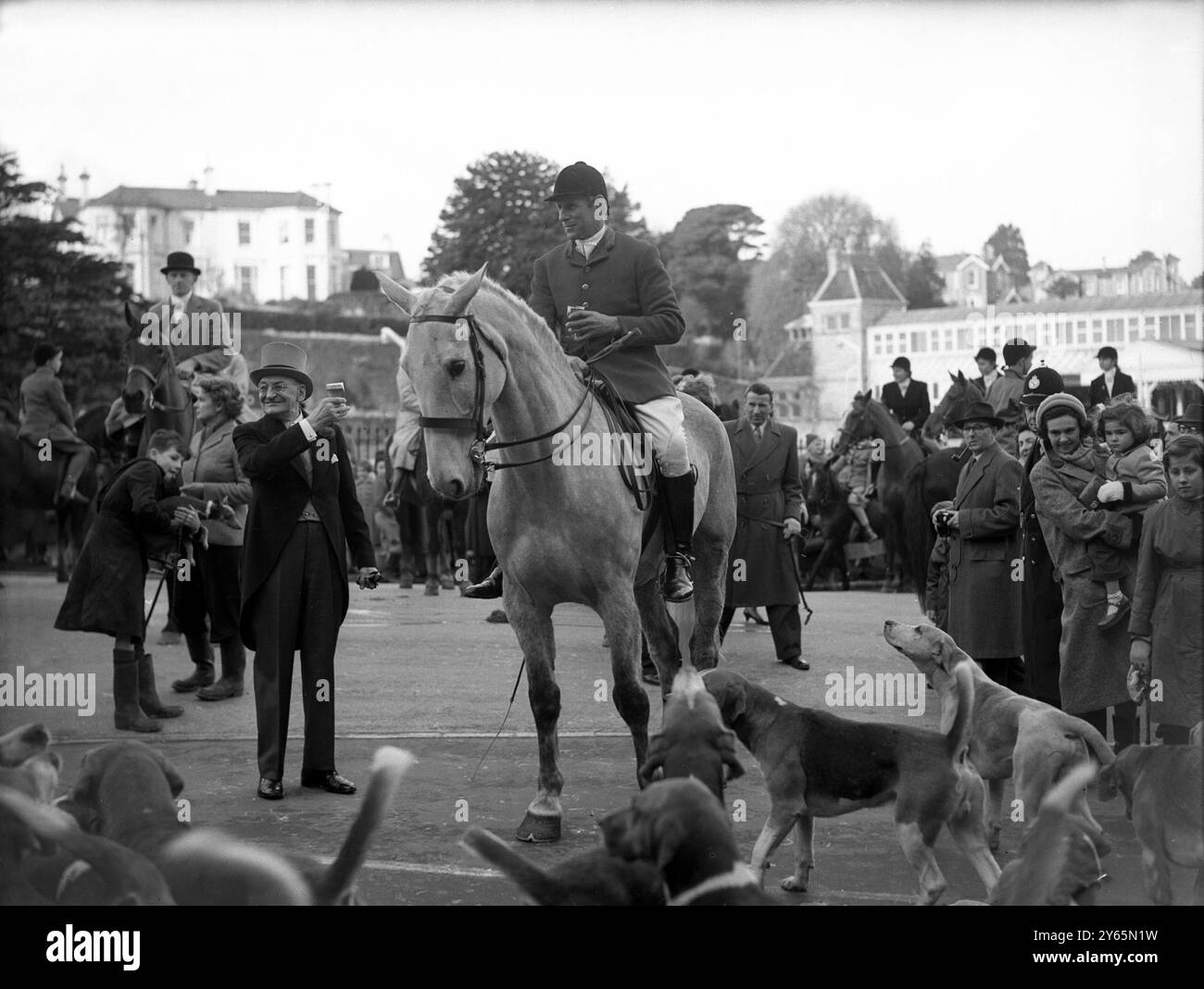Mr Paul , Manager of the Grand Hotel , Torquay , wishes the Master of the South Devon  Foxhounds , Mr C C Whitley , 'all the best' as the meet  prepares to move off from the hotel to hunt the fox. 14th January 1958 Stock Photo