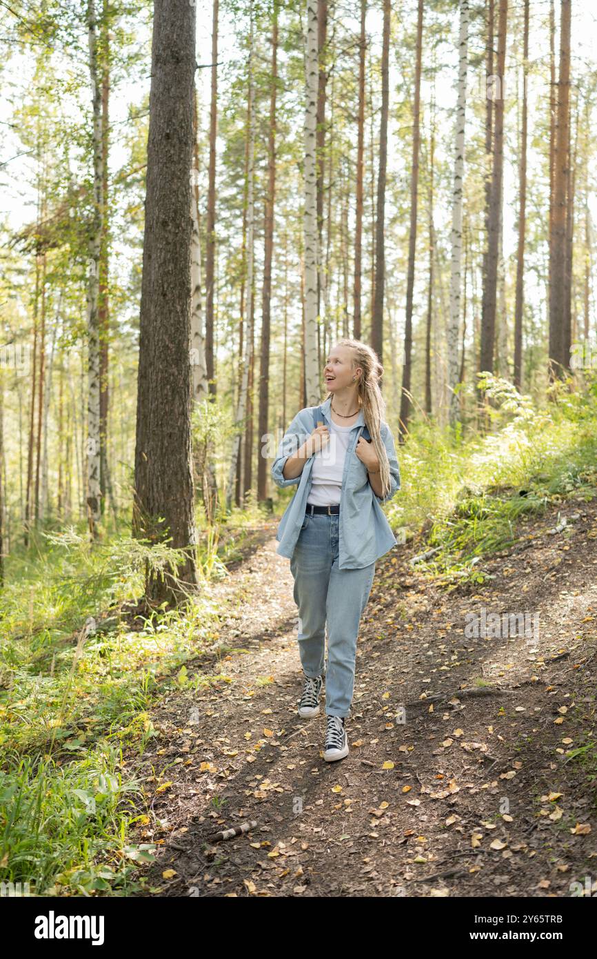 Woman walks along sunlit forest hi-res stock photography and images - Alamy