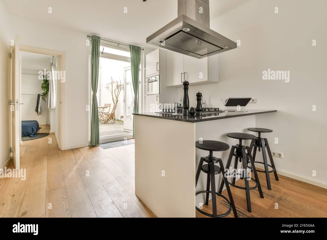Modern kitchen interior with island and bar stools leading to a cozy ...