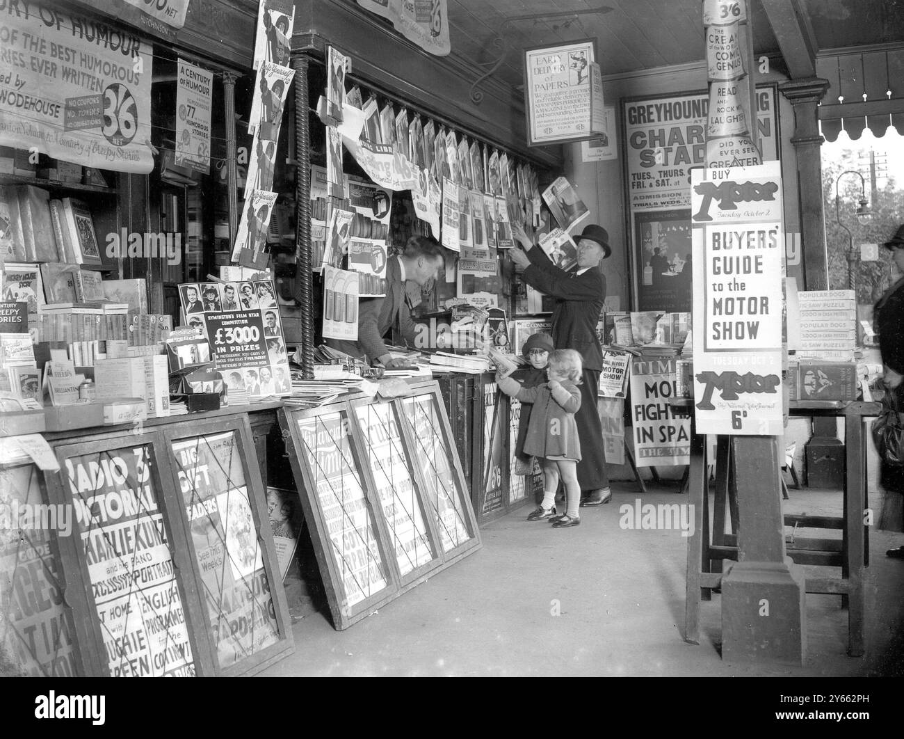 Small girl buying from a newsagent. W.H. Smith bookstall.  1934 Stock Photo