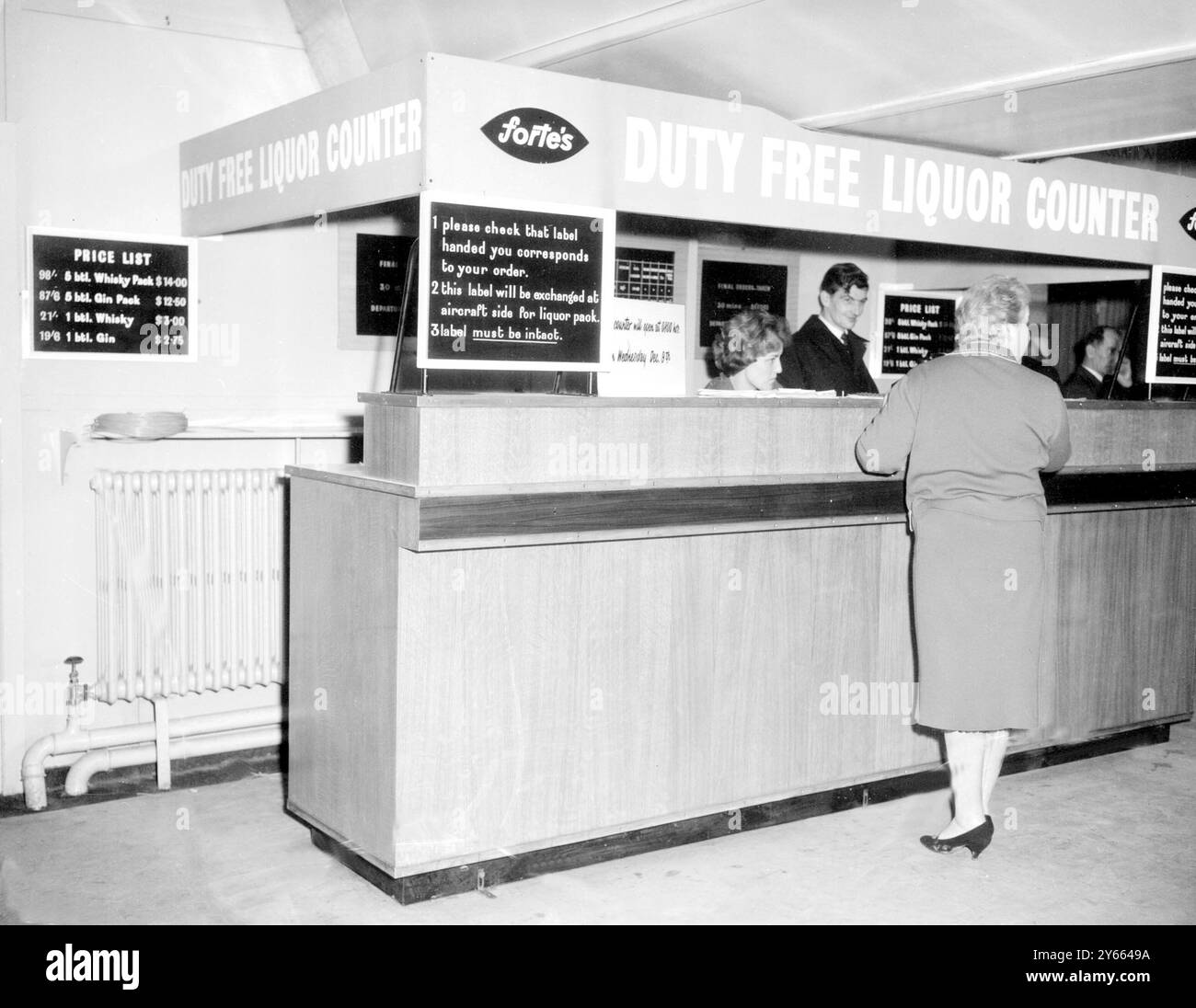 The new Duty- Free Liquor counter at London Airport, started by Fortes Caterers, was opened today. The counter is for passengers flying from the airport. They order the liquor, collect it just prior to boarding the plane. Without duty, a bottle of Whiskey costs only 21/- or $3. 9th December 1959 Stock Photo