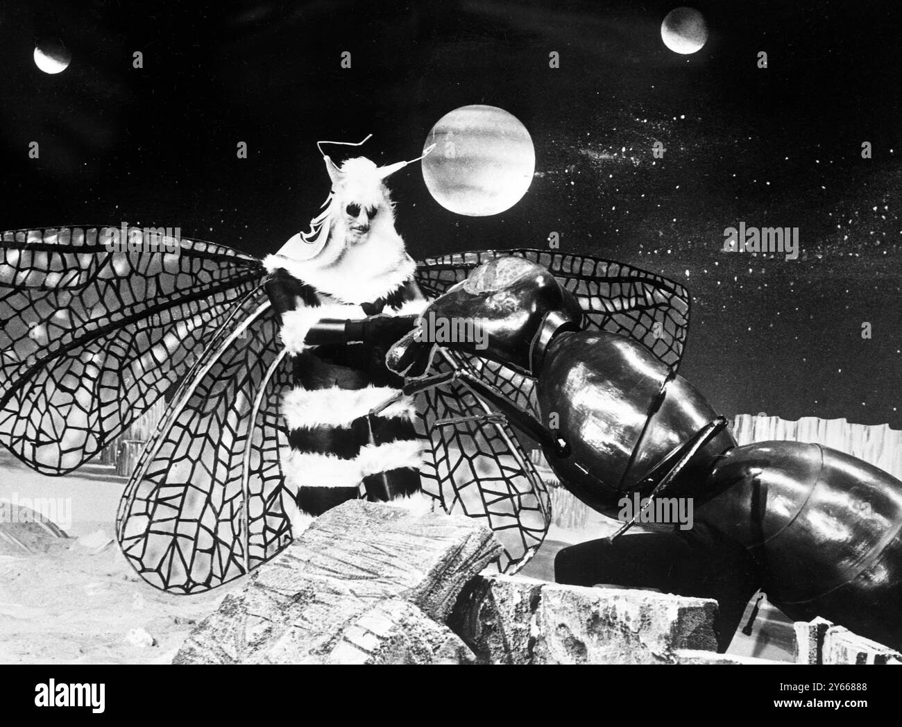London :  After the Dalek period of the famous Dr Who television serial , comes the entomological interlude represented by these two gentlemen dressed as giant and very dangerous insects .  On the right , the wasp-waisted Zarbi  , 8 feet tall , with a high IQ and an ability to communicate by a means of chirruping .  On the left , the winged  Menoptera , a monster friendly to man , with a furry body and a ermine-looking mantle of fur about the neck.  They will be seen on 13 February , when  Dr Who and his associates land on the mysterious planet Vortis .7 January 1965 Stock Photo