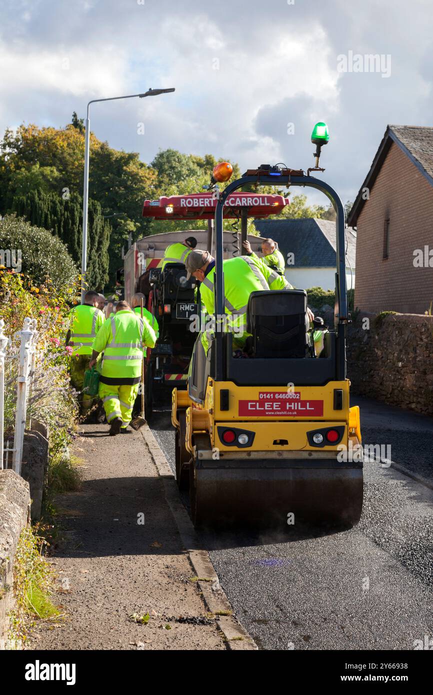 Workmen repairing road surface, Rhu, Scotland showing tar layer and road roller, Rhu, Scotland Stock Photo