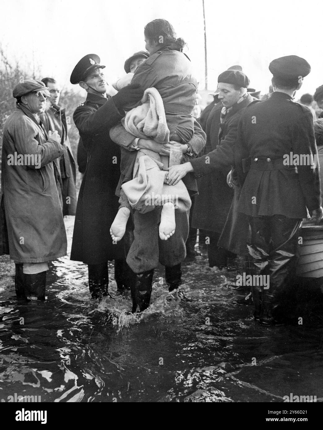 A barefooted woman is carried through the floods at Jaywick Essex . 1st February 1953 Stock Photo