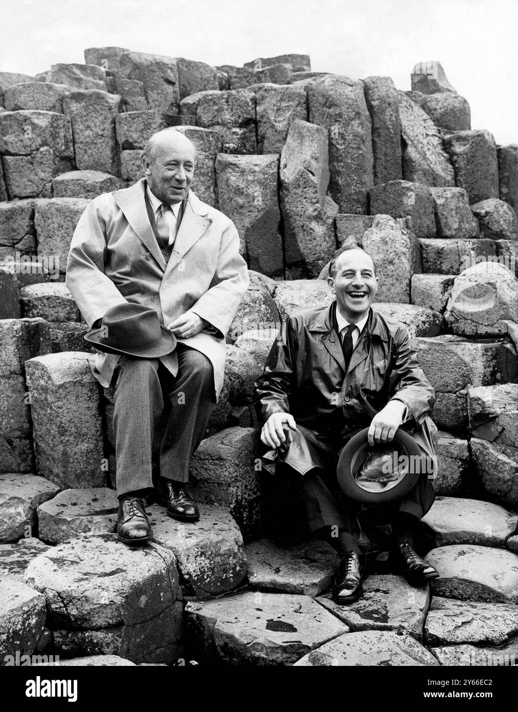 'Wishing Chair' - Giant's Causeway Opened The Prime Minister of Northern Ireland, Captain Terence O'Neill, is pictured (right) sitting in the 'Wishing Chair' formed among the basalt columns when he opened the Giant's Causeway to the public.  Seen with him is Lord Antirm.  According to legend, a person's wish will be granted if it is made while sitting in the 'Chair'.  The Giant's Causeway, which has often been called 'The Eighth Wonder of the World', is situated on the north coast of Antrim where the action of volcano, ice, sea and wind over a period of some 50 million years has produced a ser Stock Photo