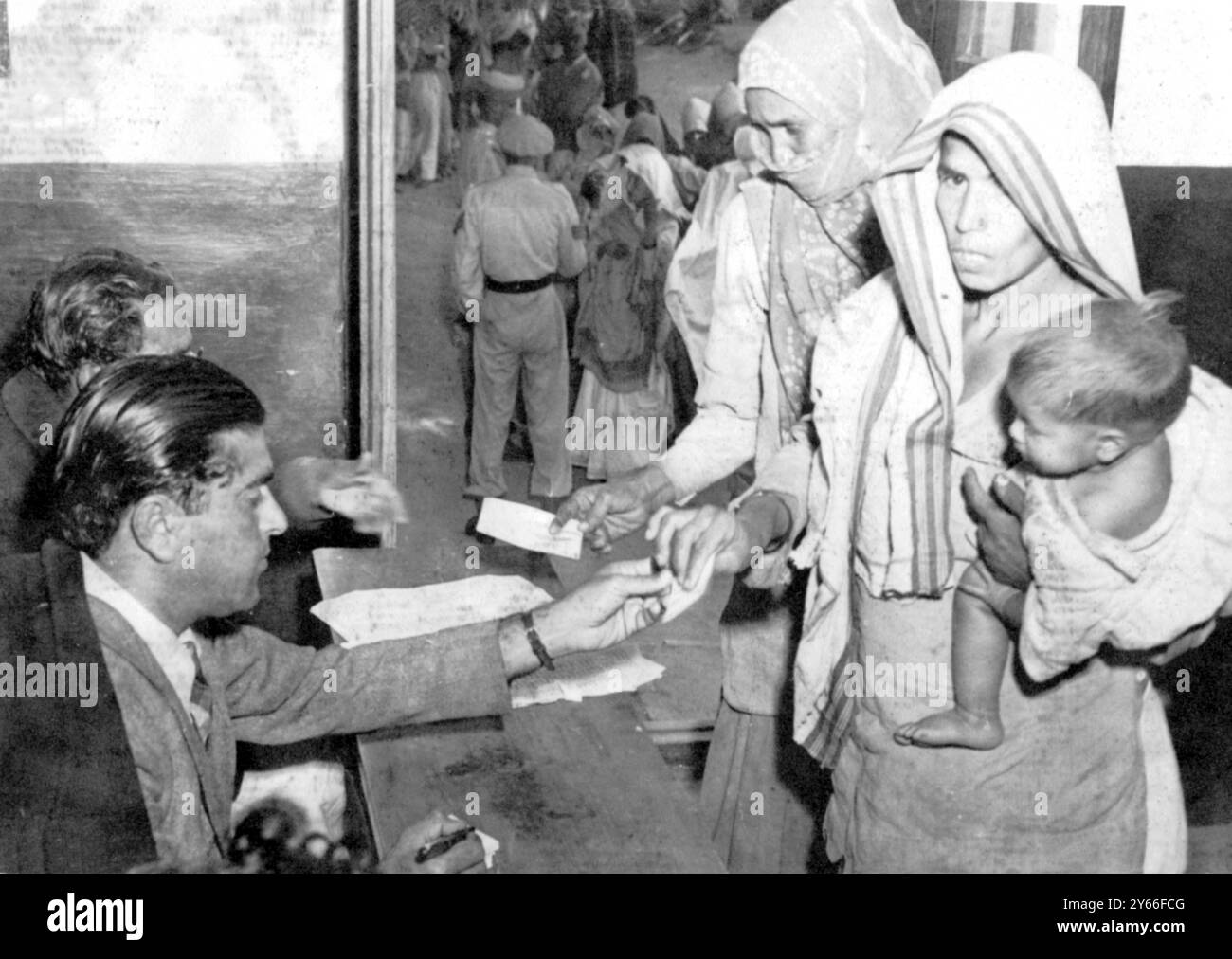 Women of Outer Delhi are keen to vote. Here they are seen receiving ballott papers at one of the booths. Thier forefingers were marked with indelible ink when they voted to make sure nobody voted twice 18 January 1952 Stock Photo