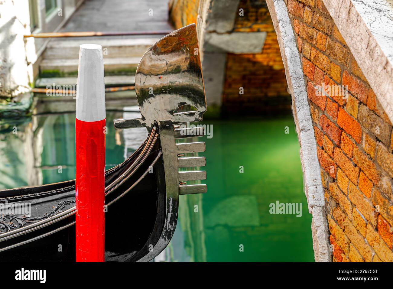 Close up of hhe metal blade or fero da prora on the front of a gondola at Ponte dei Ferali in the San Marco sestiere of Venice,Italy Stock Photo