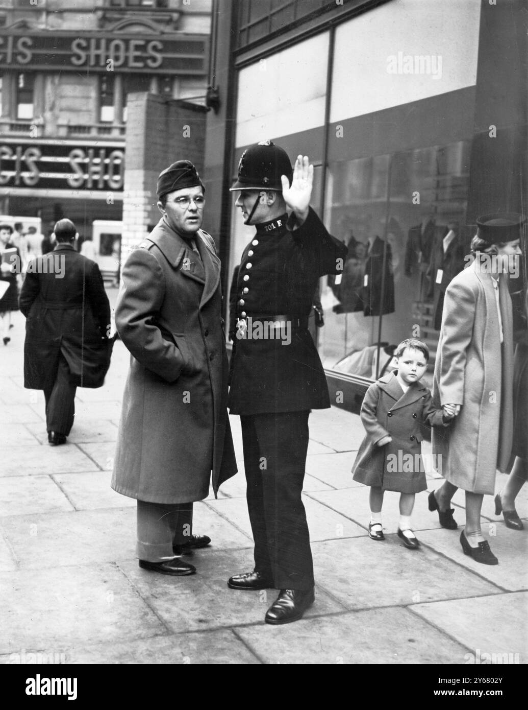 Policeman shows US Officer the way to the American Club. Corporation Street, Birmingham, England - WW2 Stock Photo