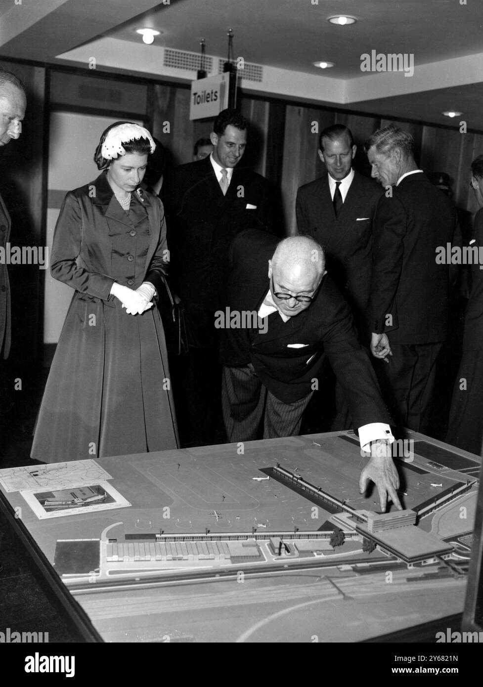 Queen Elizabeth II studies a model of the new terminal building at Gatwick Airport.  She also opened the airport officially by unveiling a plaque shortly afterwards. 9th June 1958 Stock Photo