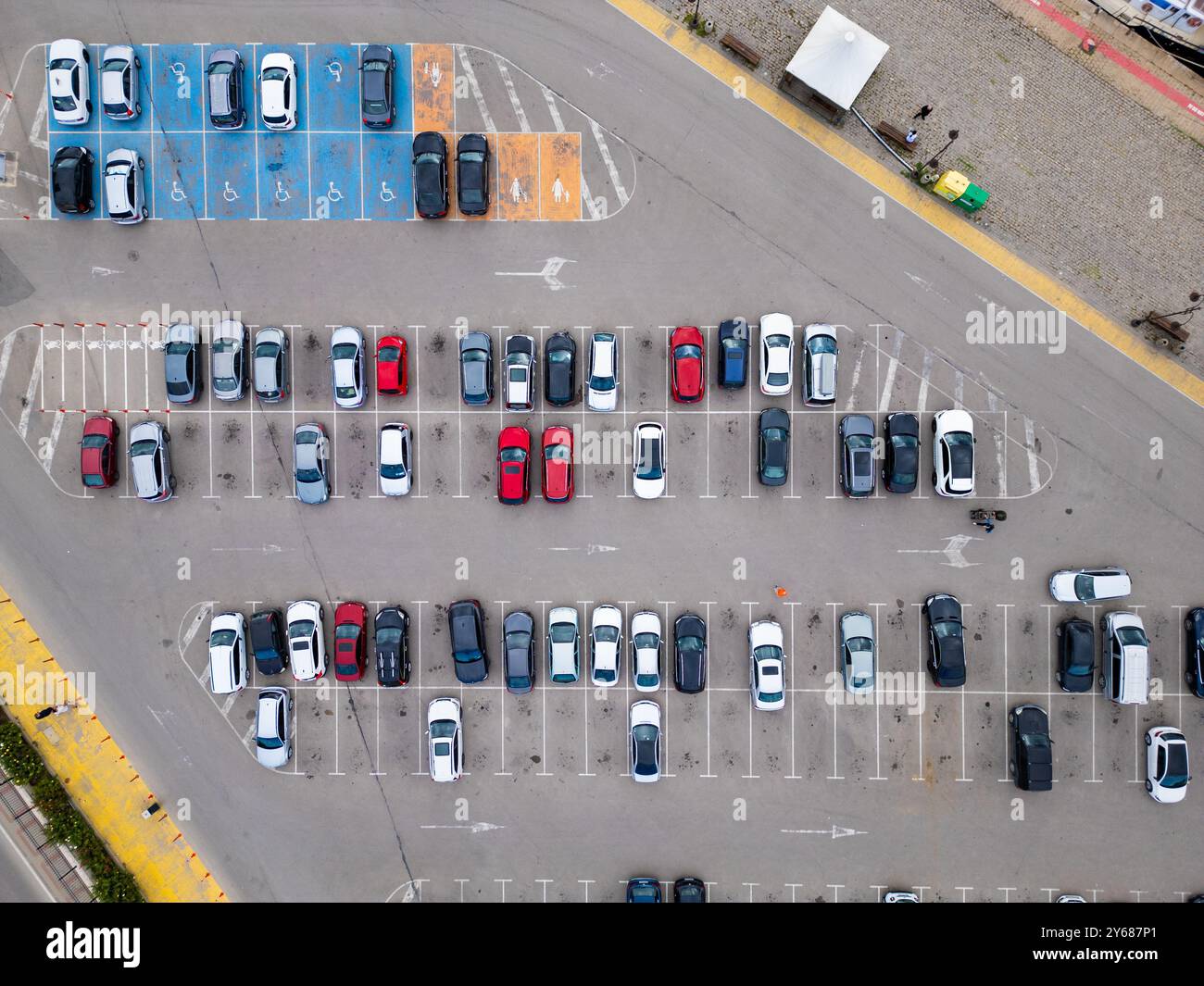 Aerial view of a busy parking lot filled with various cars during ...