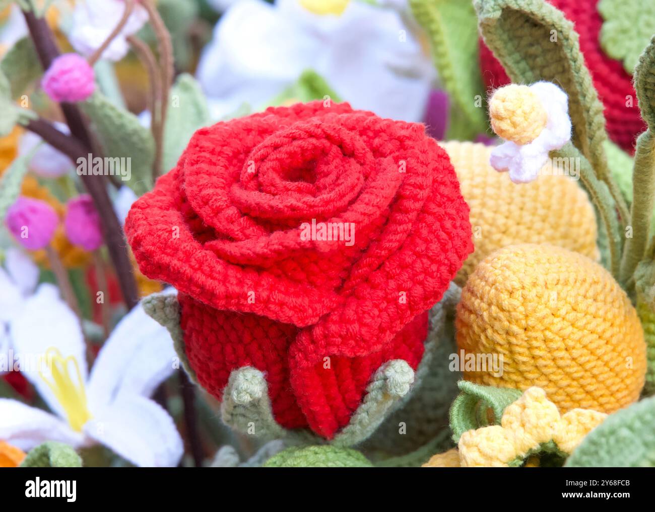 Close up on hand crafted crochet vibrant red rose flowers with a ...