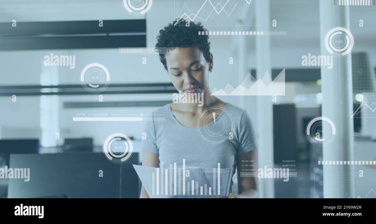 Analyzing documents, businesswoman with data visualization image over office background Stock Photo
