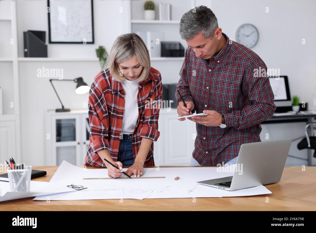 Architects making engineering drawing at wooden table in office Stock Photo