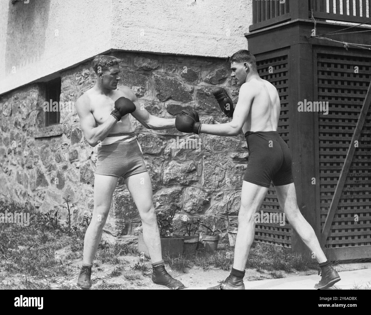 Wells & Coffey, Photo shows English boxer Bombardier Billy (William Thomas) Wells (1889-1967) sparring with Jim Coffey, the Roscommon Giant (1891-1959), in Rye, New York, to prepare for a fight with Al Panzer., 1912, Boxing, Glass negatives, 1 negative: glass; 5 x 7 in. or smaller. Stock Photo