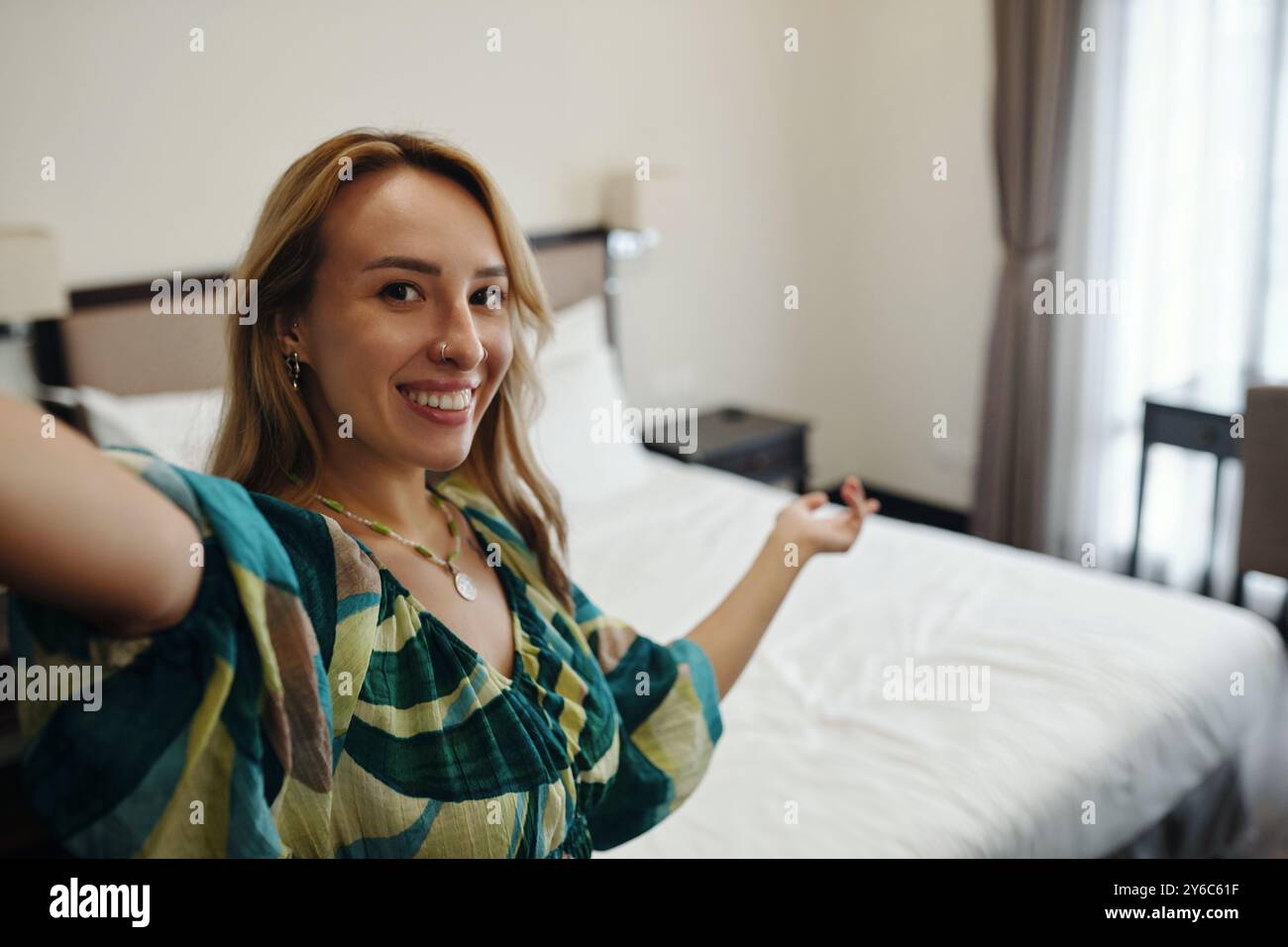 Portrait of Smiling Woman Taking Selfie in Bedroom Stock Photo