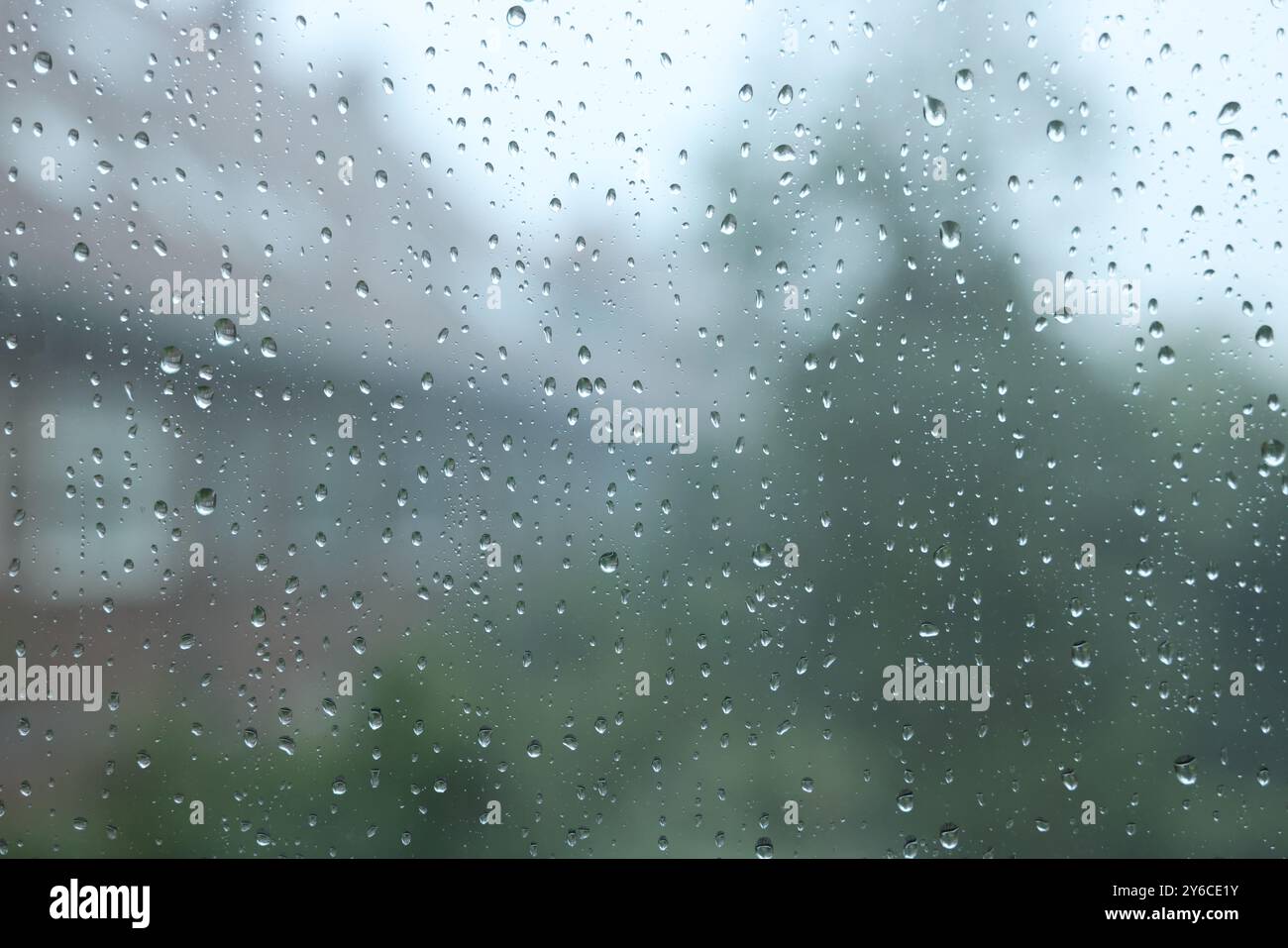 View on buildings through window with water droplets on rainy day ...