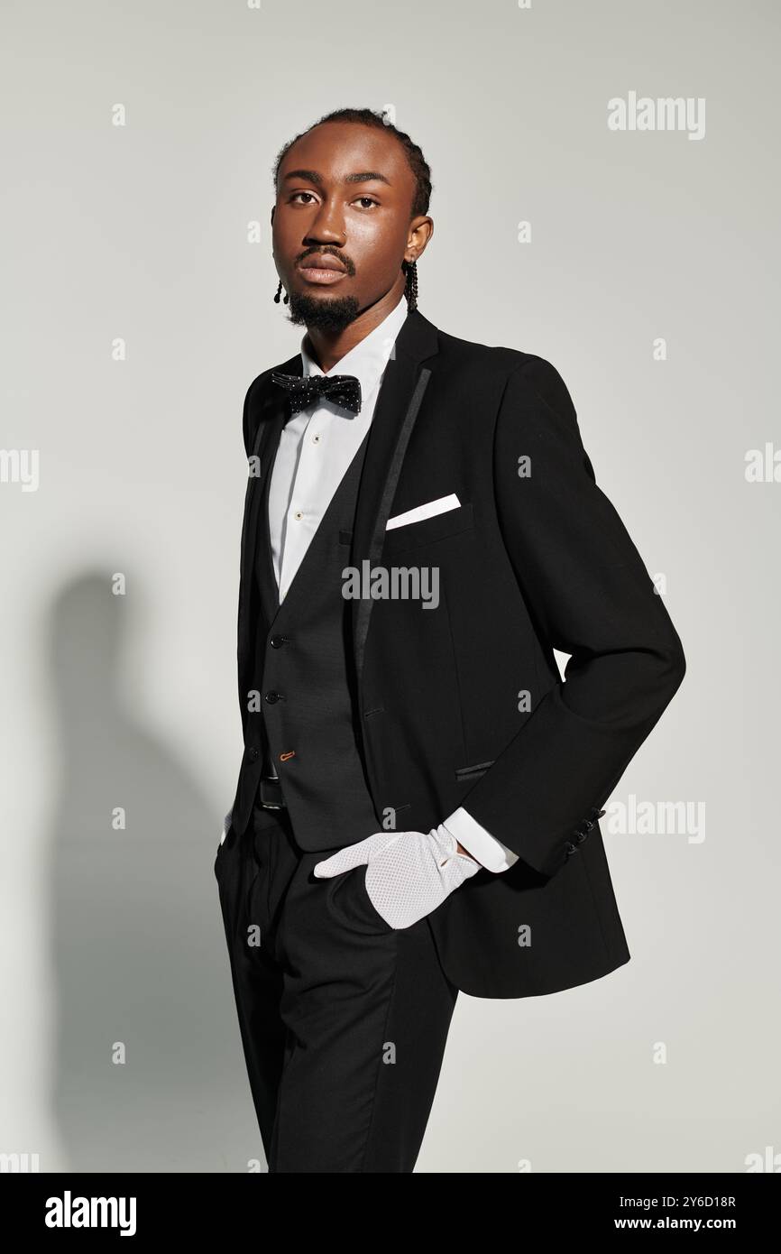 A young African American man dressed elegantly in a suit, vest, and bow ...