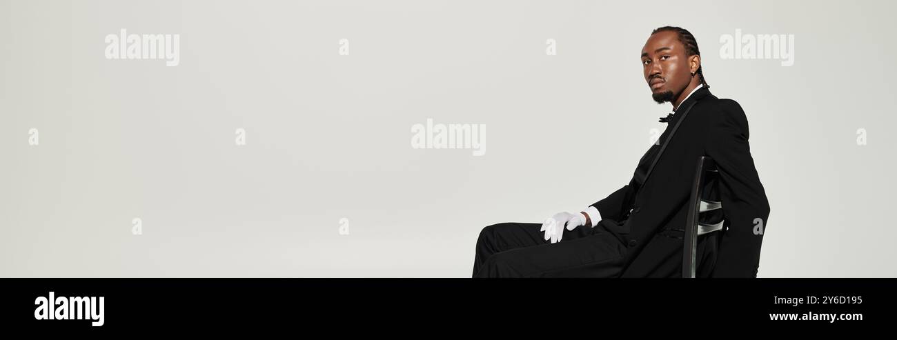 A stylish young African American man poses confidently in a formal suit ...