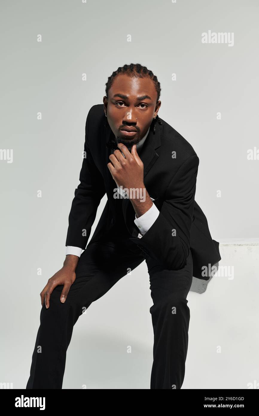 A young man poses confidently in a stylish suit and vest against a ...