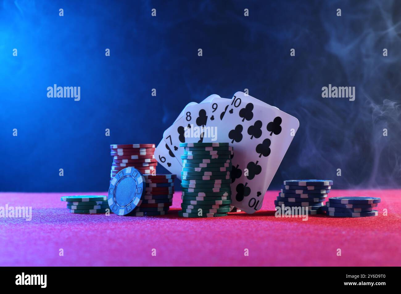 Poker chips and playing cards on pink table Stock Photo