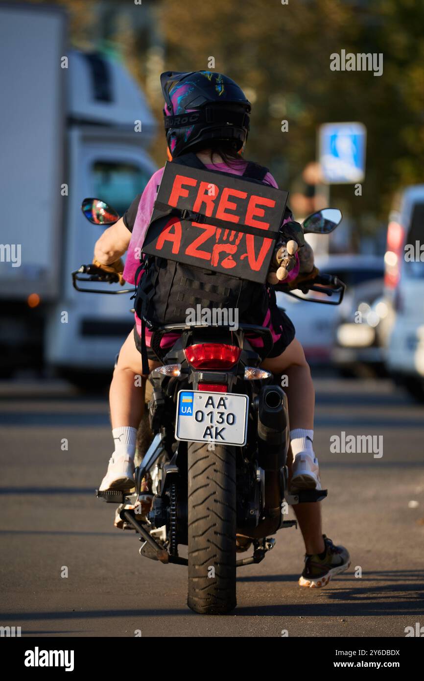 Ukrainian activists ride on a motorbike with a sign Free Azov at a ...
