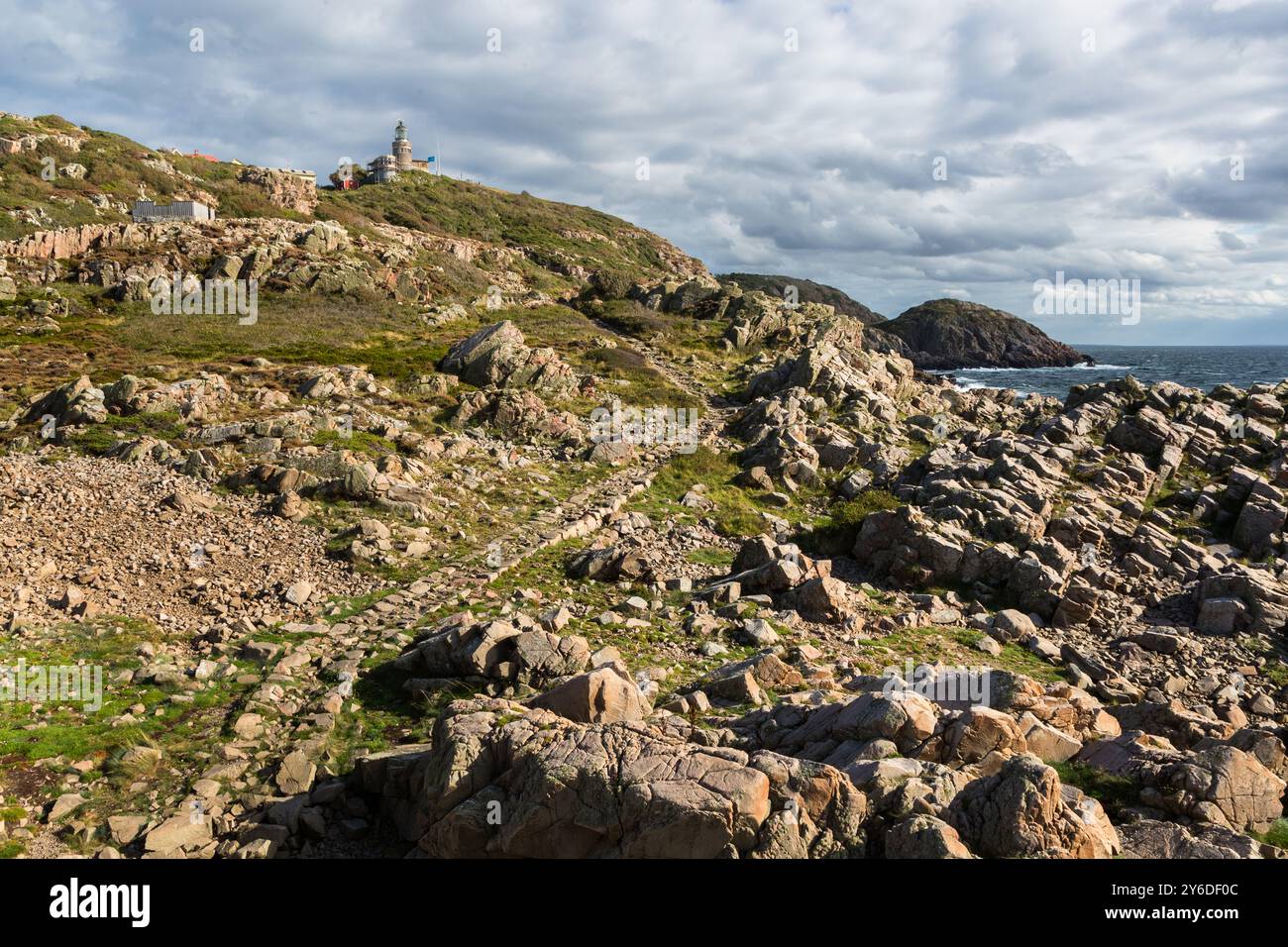 The hiking trail along the coast of Kullaberg is characterized by a dramatic landscape with steep cliffs. At the tip of the Kullaberg peninsula stands the Kullens fyr lighthouse. Italienska vägen, Höganäs kommun, Skåne, Skåne, Sweden Stock Photo