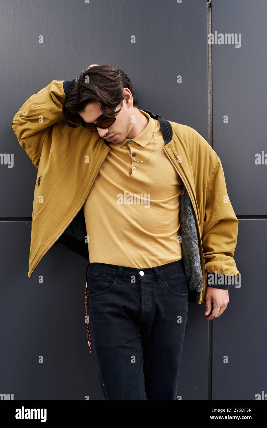 A young handsome man confidently shows off his trendy autumn outfit ...