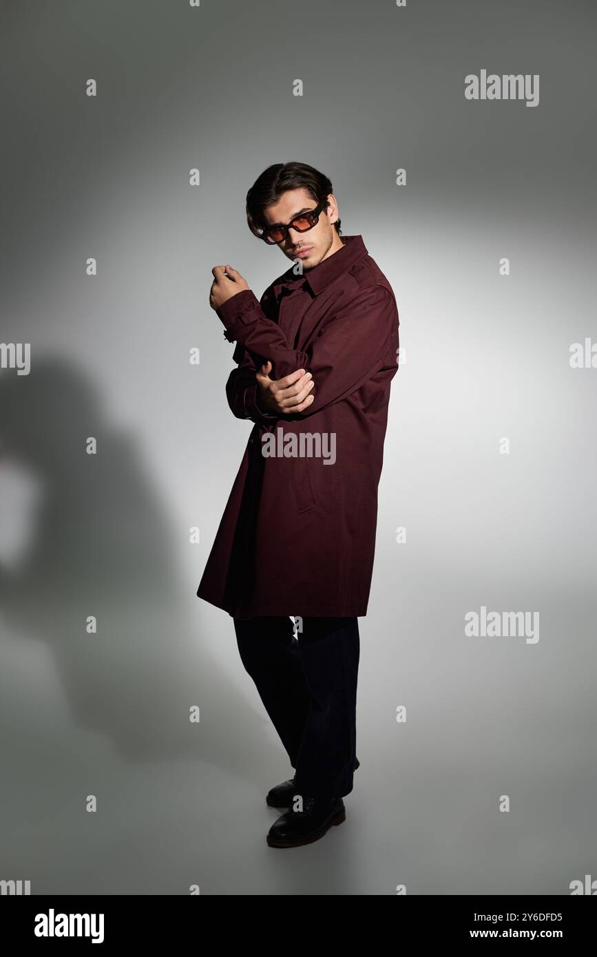 A stylish young man poses confidently in a fashionable autumn outfit ...