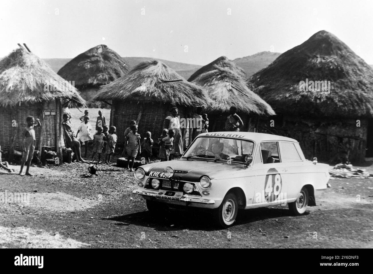 MOTOR RALLY EAST AFRICAN SAFARI PAT MOSS DRIVES THROUGH VILLAGE NEAR NAIROBI   ; 9 APRIL 1963 Stock Photo