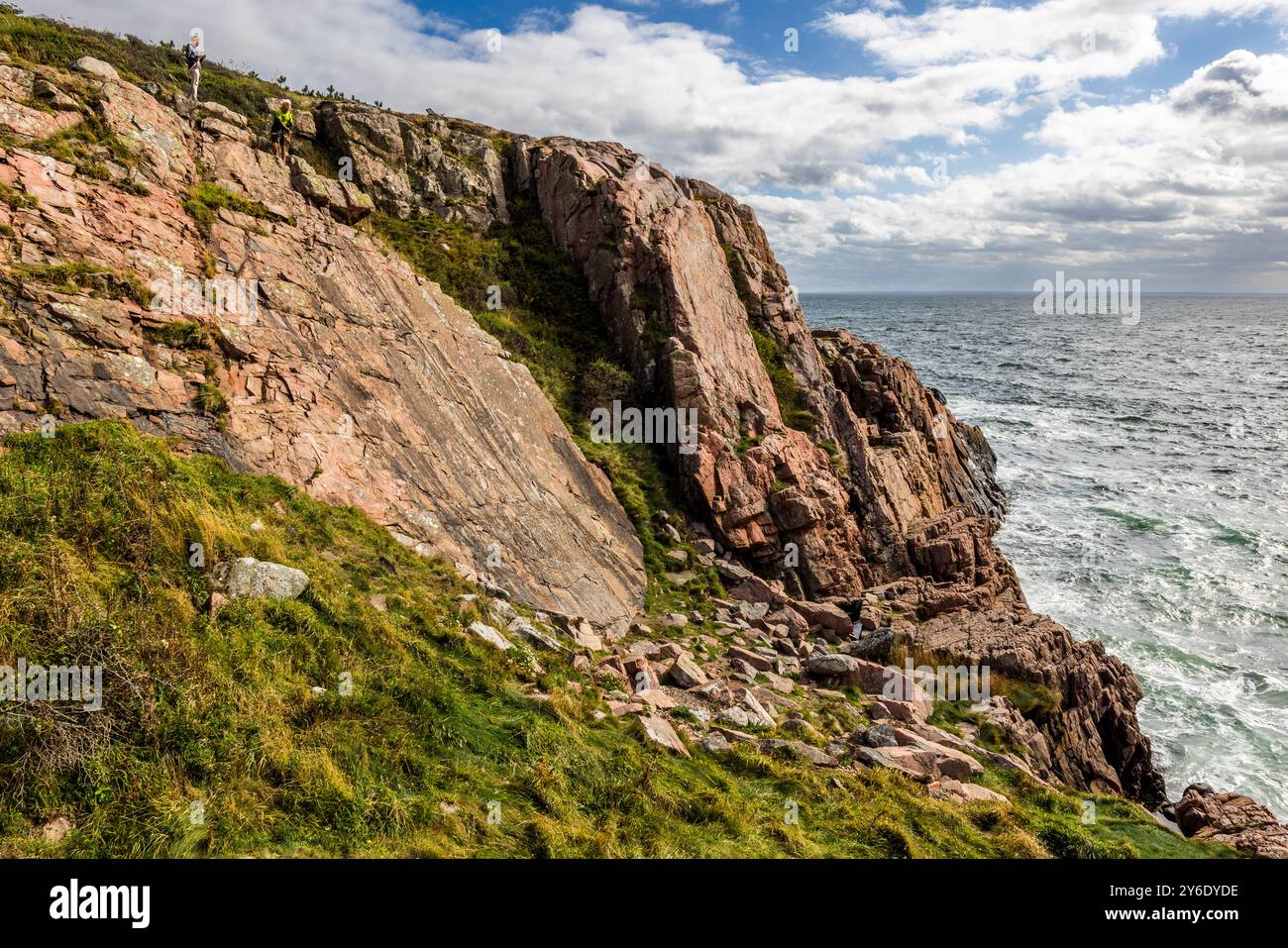 Cliffs on the Kullen peninsula. The coastal hiking trail between Mölle and the Kullen lighthouse is a rocky region with steep cliffs and a height of up to 188 meters. You can practise abseiling on the rugged rocks of the Kullaberg peninsula under the guidance of a guide. Italienska vägen, Höganäs kommun, Skåne, Sweden Stock Photo