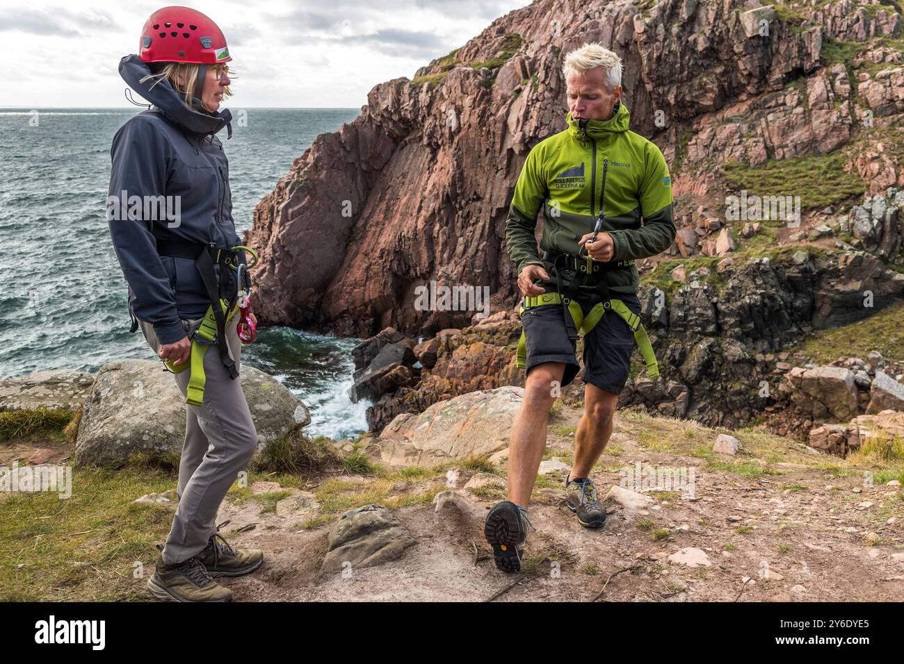 Outdoor activities in the Kullaberg nature reserve. Here are instructions for abseiling on the rocky coast. You can practise abseiling on the rugged rocks of the Kullaberg peninsula under the guidance of a guide. Italienska vägen, Höganäs kommun, Skåne, Sweden Stock Photo