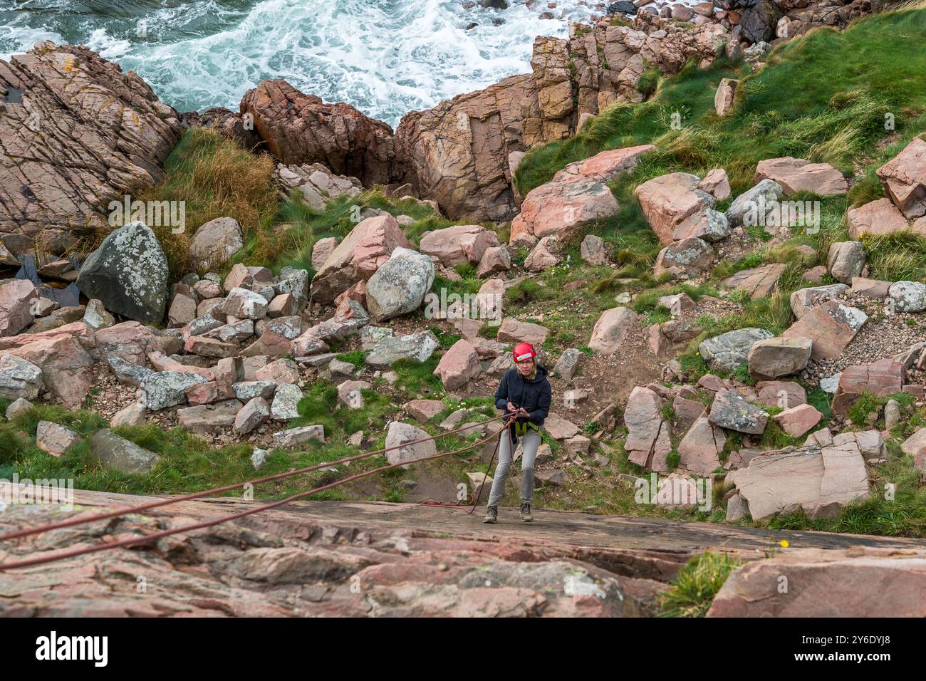 Outdoor activities in the Kullaberg nature reserve. Abseiling on the rocky coast here. You can practise abseiling on the rugged rocks of the Kullaberg peninsula under the guidance of a guide. Italienska vägen, Höganäs kommun, Skåne, Sweden Stock Photo