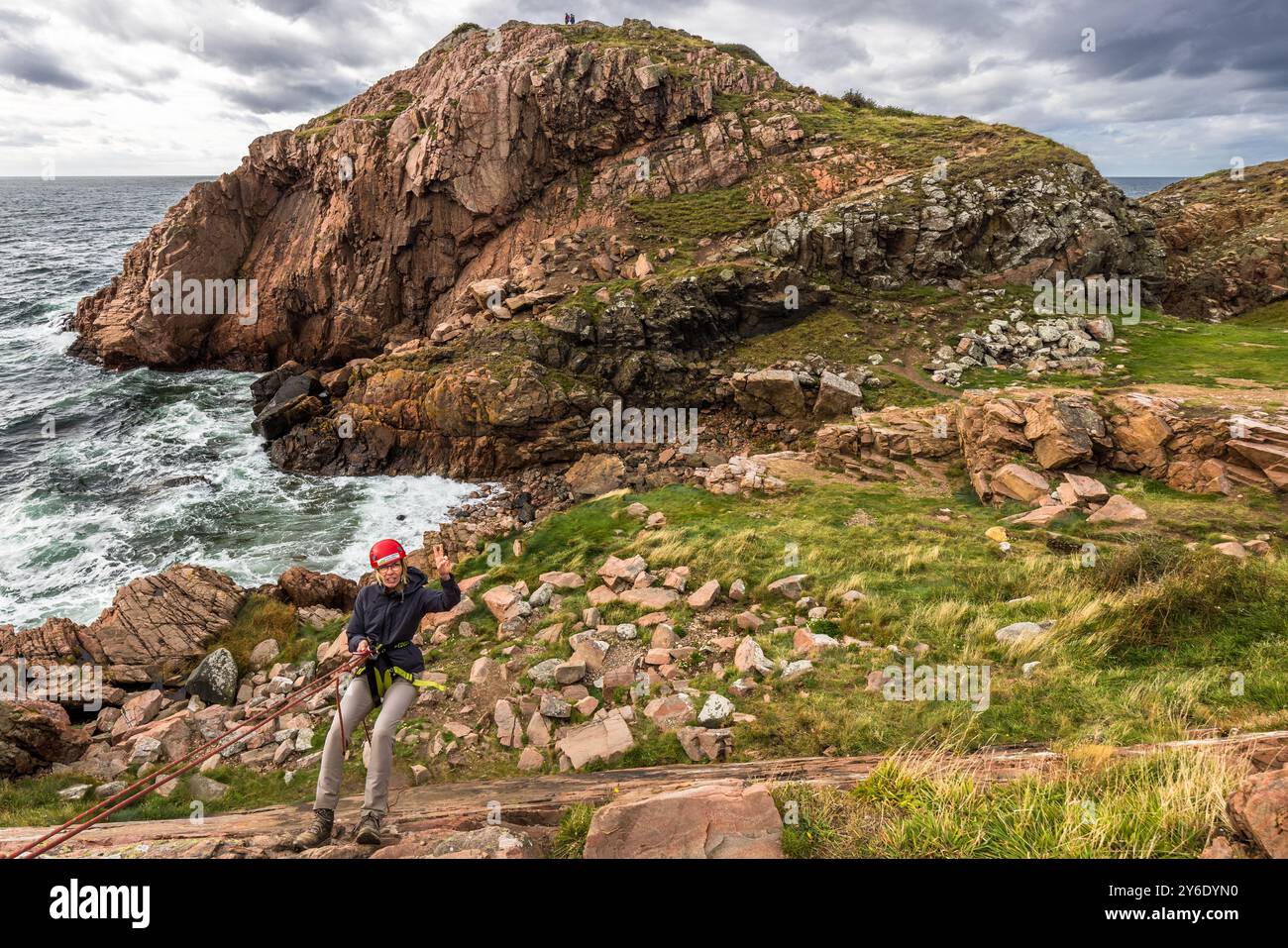 Outdoor activities in the Kullaberg nature reserve. Abseiling on the rocky coast here. You can practise abseiling on the rugged rocks of the Kullaberg peninsula under the guidance of a guide. Italienska vägen, Höganäs kommun, Skåne, Sweden Stock Photo