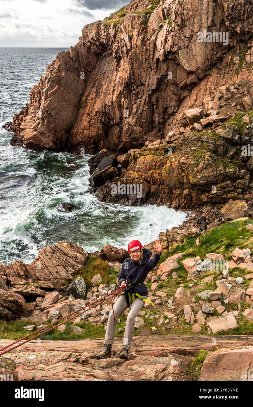 Outdoor activities in the Kullaberg nature reserve. Abseiling down the cliffs. The steep cliffs are up to 188 meters high. You can practise abseiling on the rugged rocks of the Kullaberg peninsula under the guidance of a guide. Italienska vägen, Höganäs kommun, Skåne, Sweden Stock Photo