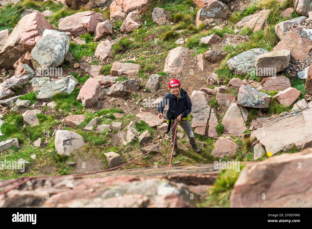 Outdoor activities in the Kullaberg nature reserve, here abseiling on the rocky coast, can also be booked as a team event. You can practise abseiling on the rugged rocks of the Kullaberg peninsula under the guidance of a guide. Italienska vägen, Höganäs kommun, Skåne, Sweden Stock Photo