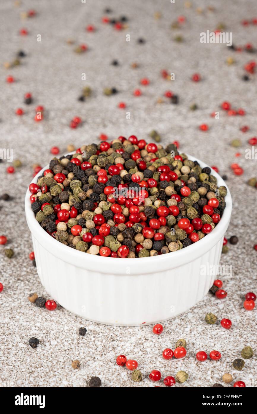 Multicolored peppercorns on a stone gray background. Stock Photo