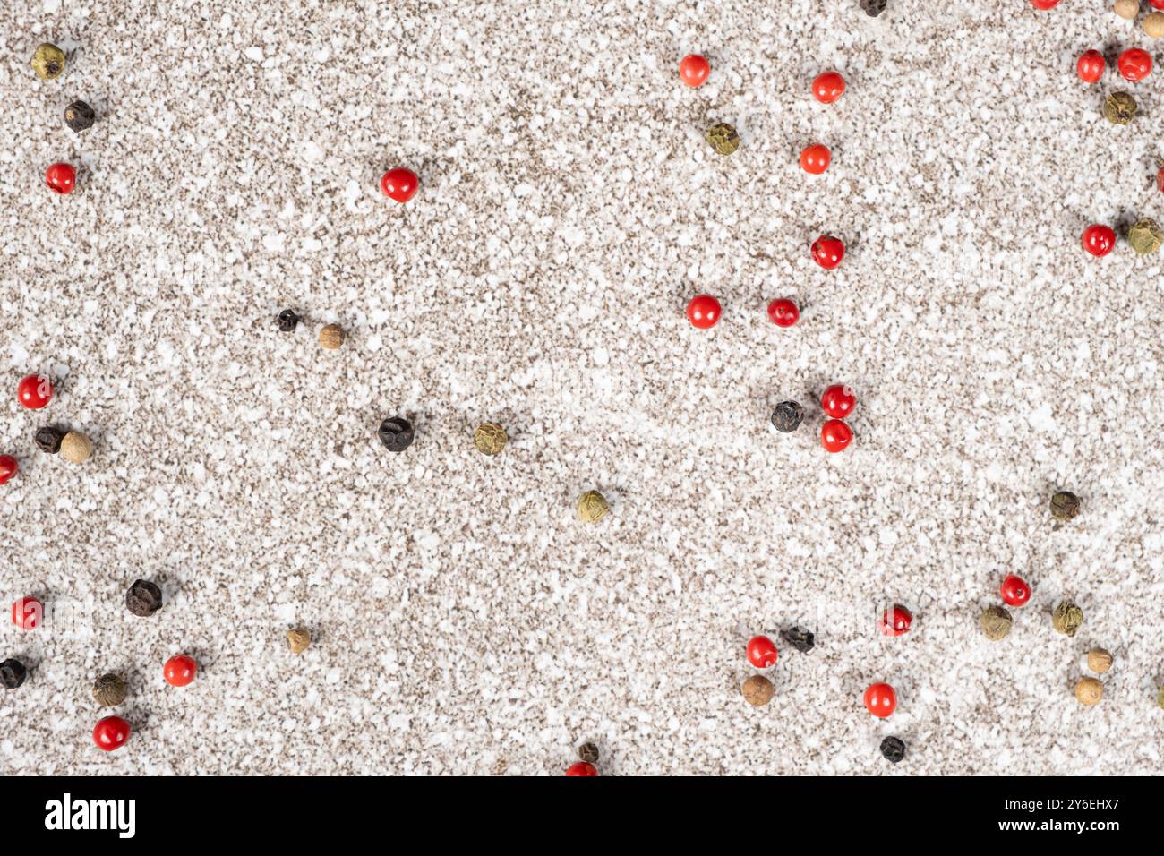 Multicolored peppercorns on a stone gray background. Stock Photo