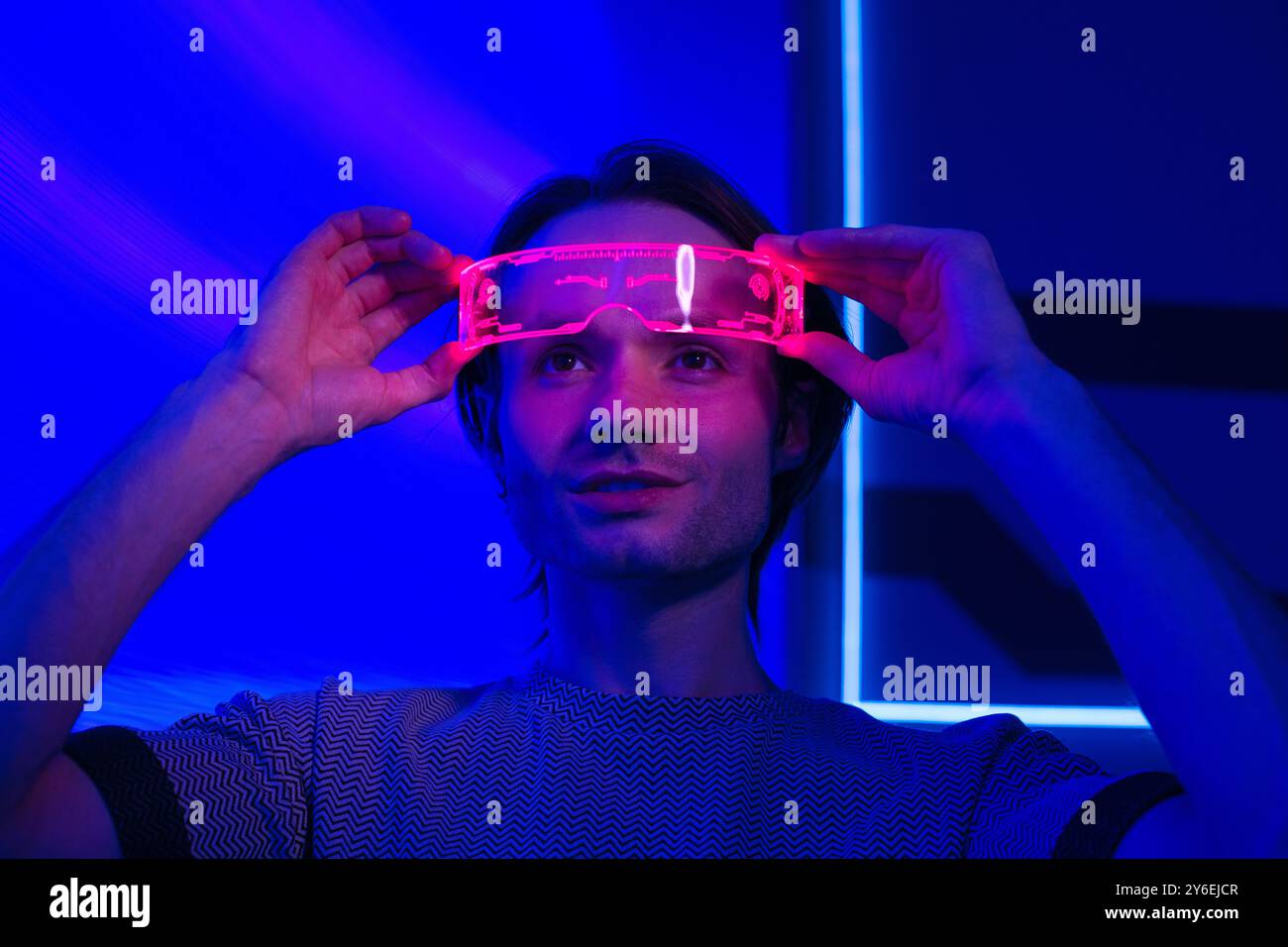 Creative futuristic man with smart neon glasses in a neon room a neon ...