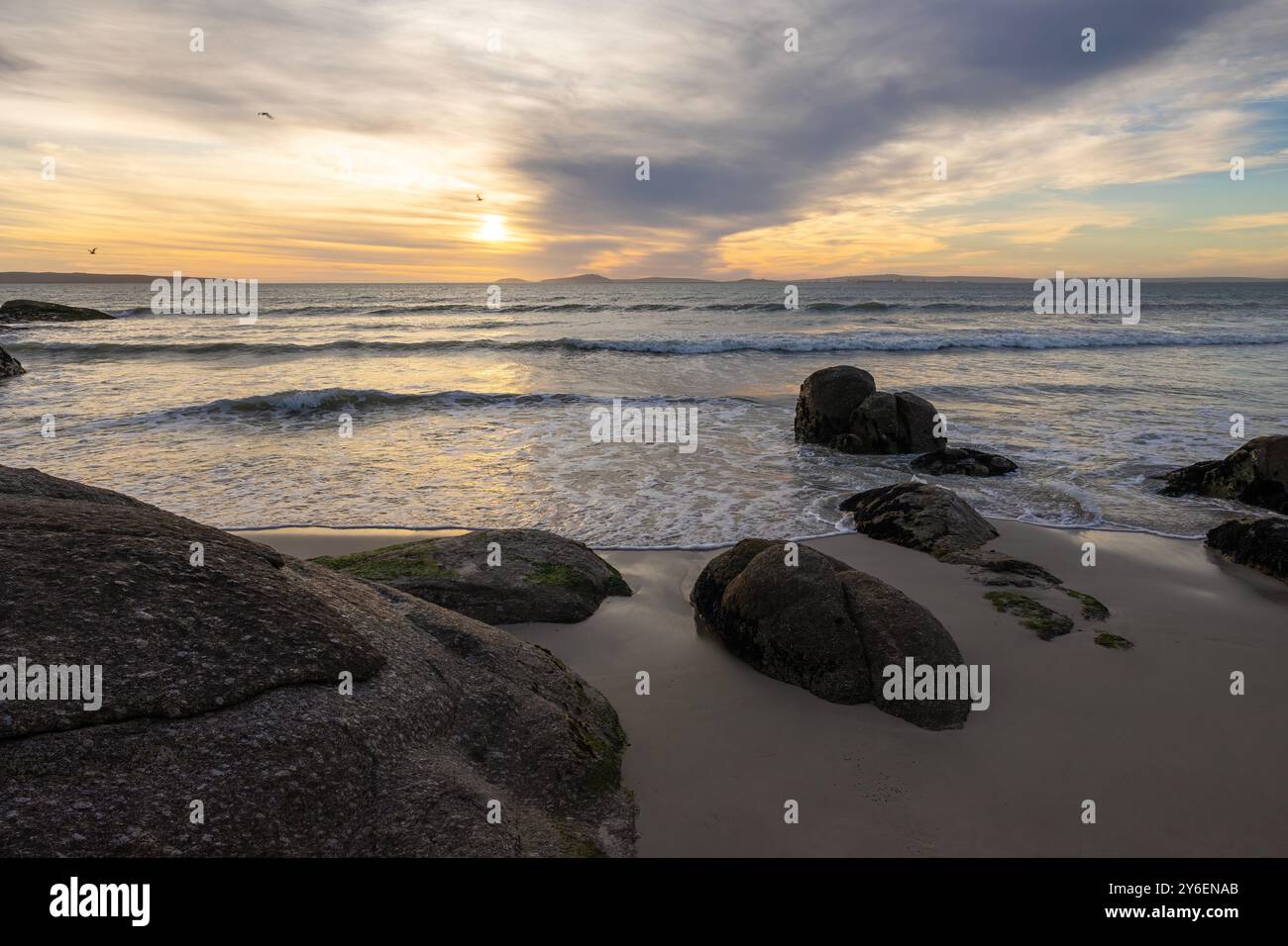 Sunset Over Langebaan; Golden Light, Rolling Waves, and Rugged Coastal Beauty Stock Photo