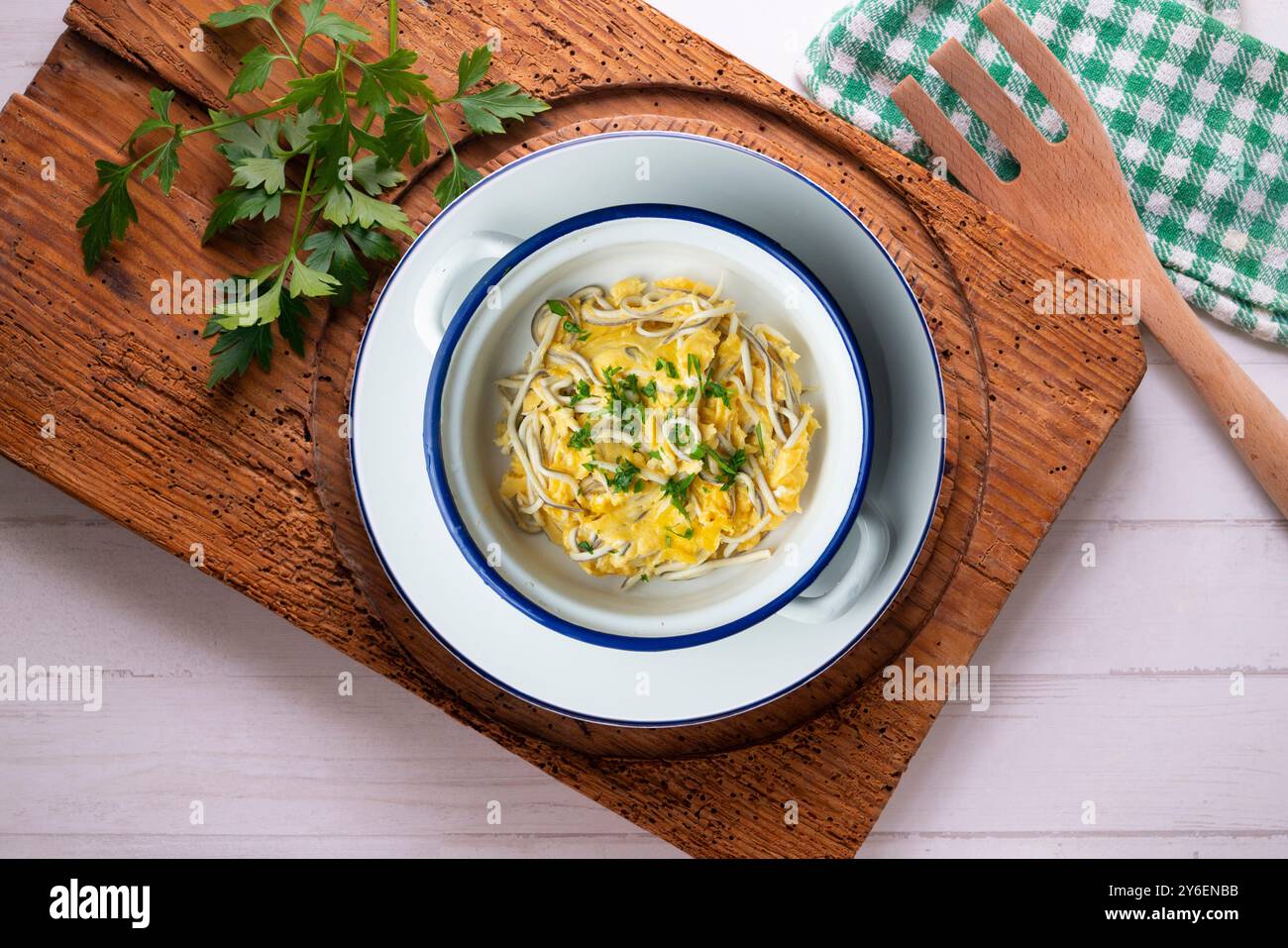 Scrambled eggs with baby eels and garlic. Top view table with decorations. Stock Photo